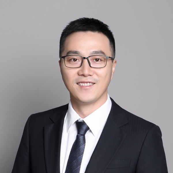 Yuan Shen standing in front of a light background.