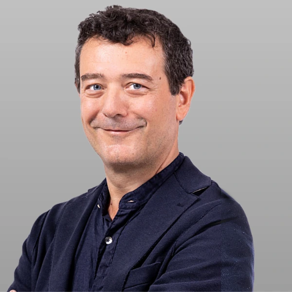 Fabrizio Conicella standing in front of a white wall.
