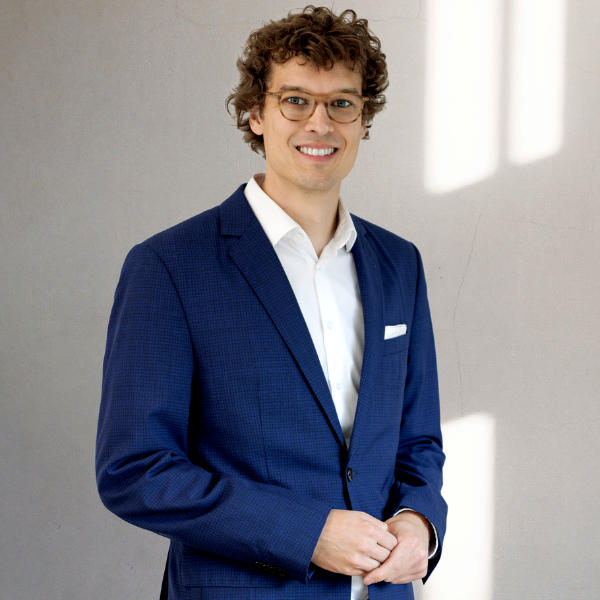 Dominik Lückmann standing and smiling into the camera