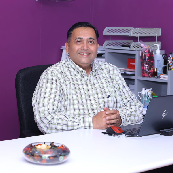 Malathkar sitting and smiling into the camera.